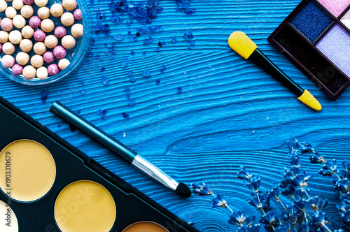 cosmetic palette and lavender flowers on wooden background