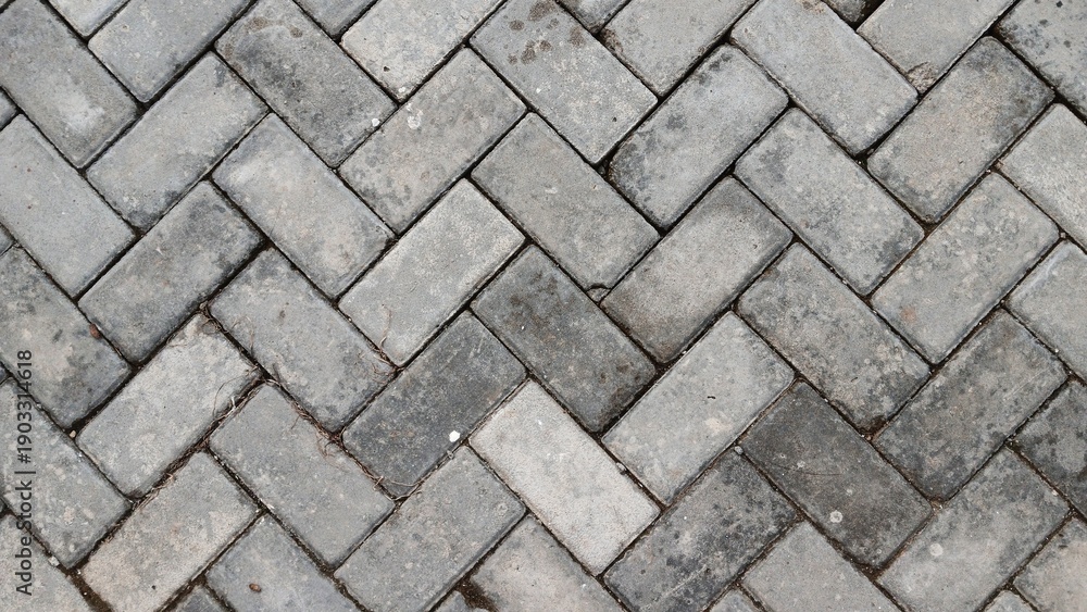 Obraz premium Grey herringbone paving block texture background. walkway surface.