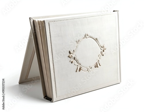 Light beige, leather-bound book, slightly open, with decorative embossed frame on cover