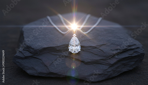 Elegant Diamond Necklace Pendant Resting on Stone Surface: Sparkling pear-shaped diamond pendant on dark textured stone surface with light flare.
