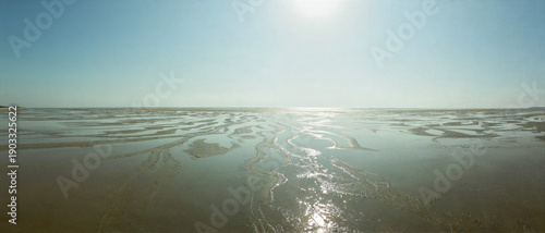 Sunlit Tidal Flat at Sunrise with Water Channels and Reflection, Minimal Seascape Panorama