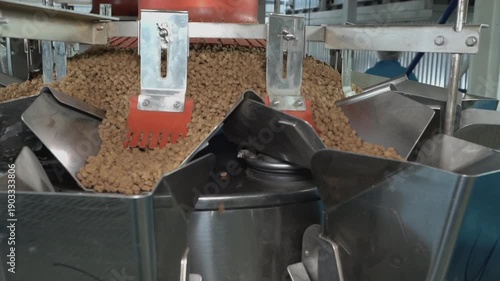 Multihead weigher machine precisely portions dry granular pet food on an automated industrial packaging line