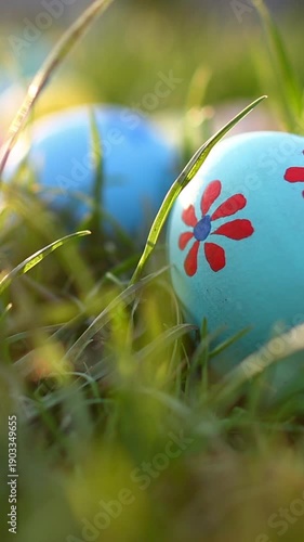  Colorful Easter eggs on green grass in sunlight. Vertical