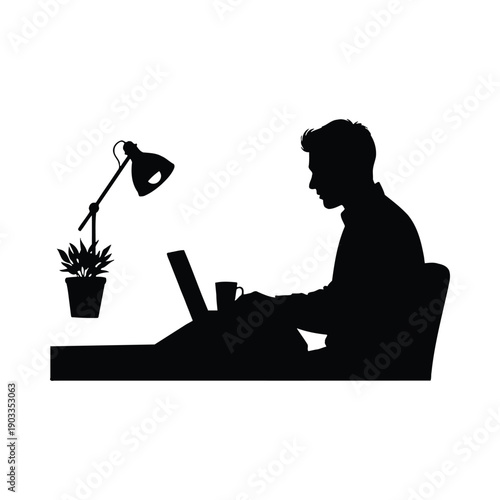 silhouette of a man working on laptop at his desk 