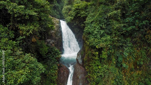 Fotografia Powerful waterfall pouring into canyon surrounded by dense tropical rainforest
