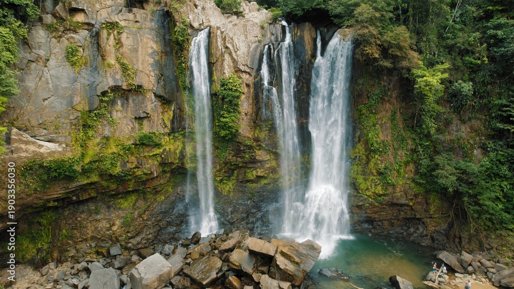 Obraz premium Wide view of Nauyaca Waterfalls surrounded by lush jungle forest in Costa Rica.