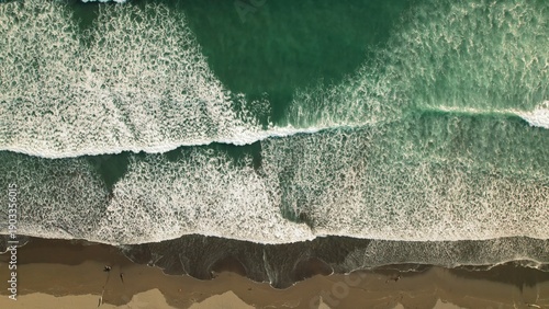 Wallpaper Mural Foamy ocean waves rolling to tropical shore with dark sand, aerial top down view. Torontodigital.ca
