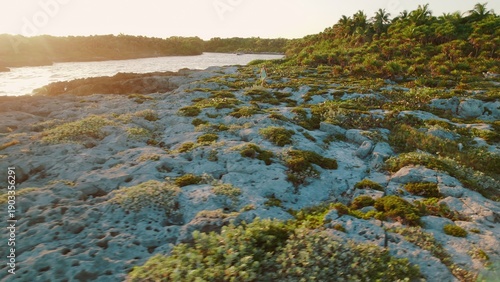 Wallpaper Mural Woman walking along rocky tropical shore near Grand Sirenis Mexico at sunset. Torontodigital.ca