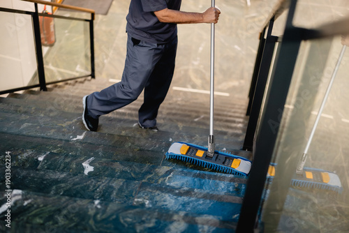 Reinigungskraft wischt die Treppe