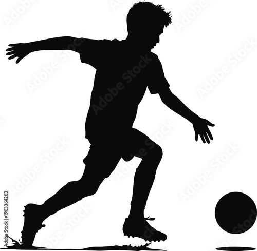 Silhouette of a young boy playing soccer kicking a ball  