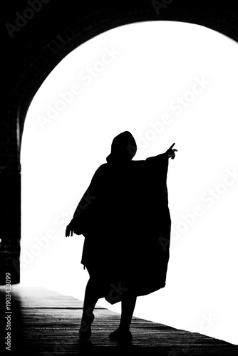 Foto Silhueta de pessoa vestida com capa de chuva.