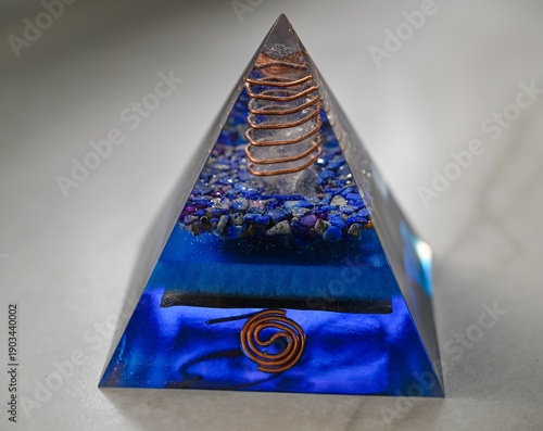 High resolution color image of a Blue Orgone Pyramid Crystal, Handmade Energy Healing Object on White Marble Background, Spiritual Protection and Cleansing Tool