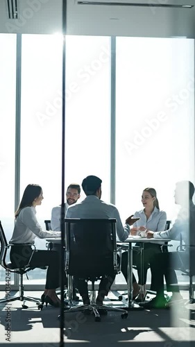 Blurred Silhouette of Business People Having a Meeting in a Modern Office Boardroom with Large Windows and Bright Natural Light