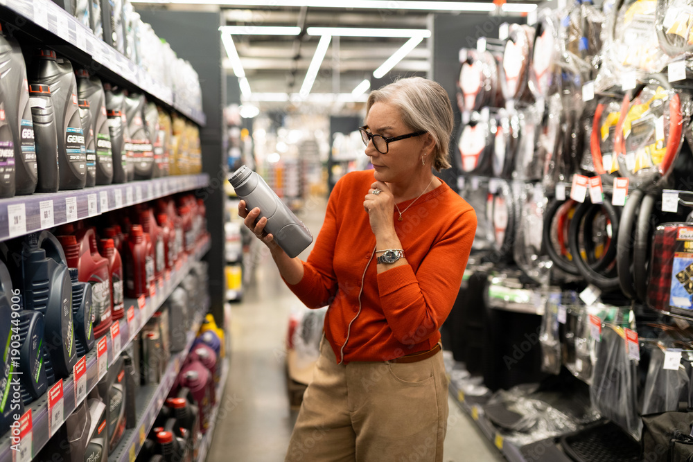 Fototapeta premium Choosing the right product in a well-stocked hardware store while considering options carefully