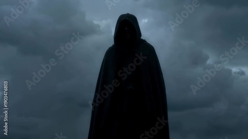 Dark hooded figure standing in mist against minimal gloomy background with soft cold light and deep shadows. Concept of mystery secrecy and anonymity