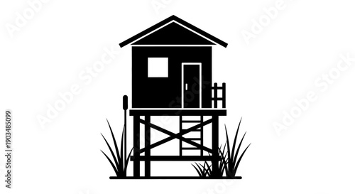 Black silhouette of a small elevated hut or hunting blind on stilts surrounded by tall grass.