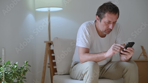 Bored adult male distracted and idle on phone, doom scrolling and procrastinating with blank expression and low energy mood. 4K.