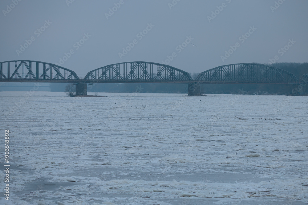 Fototapeta premium Bridges of the city of Toruń against the backdrop of the completely frozen Vistula River. Once every 14 years