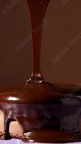 Rich chocolate sauce pouring over dessert with dark background  