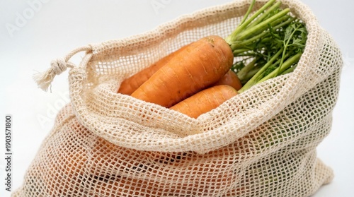 A close-up studio shot captures vibrant orange carrots with fresh green tops resting inside an eco-friendly reusable cotton mesh bag, promoting sustai
