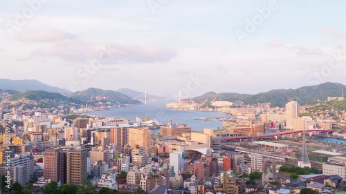 Nagasaki, Japan. Aerial timelapse made from a hill in Nagasaki, Japan, with a view over the entire center, including the bay and the hills. Cloudy and sunny day in summer, zoom in