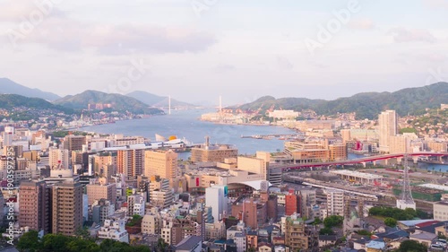 Nagasaki, Japan. Aerial timelapse made from a hill in Nagasaki, Japan, with a view over the entire center, including the bay and the hills. Cloudy and sunny day in summer, panning video