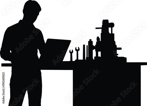Engineer working on machinery with laptop and tools