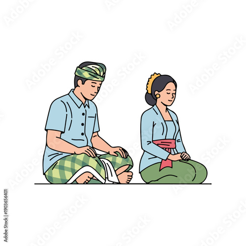 Balinese couple in traditional dress sitting and praying peacefully