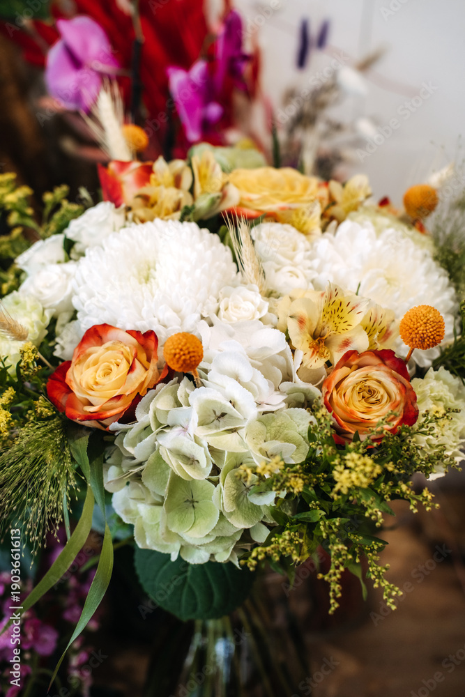 Obraz premium Vibrant mix of roses, hydrangeas, and chrysanthemums forms lush bouquet. Garden-style bouquet, wedding floral trends, natural aesthetics.