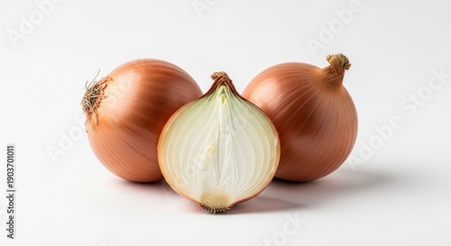 Wallpaper Mural Three yellow onions, one halved, sit on a white surface, showcasing their layers Torontodigital.ca