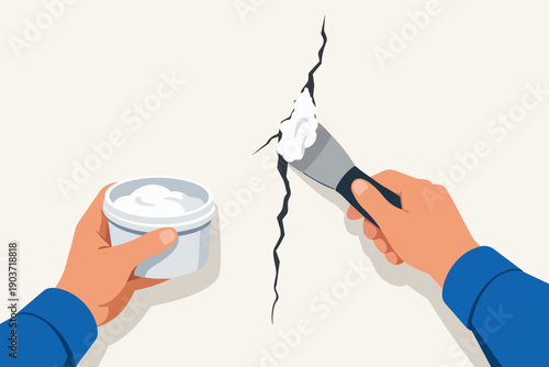 Hands repairing a wall crack filling it with putty using a spatula