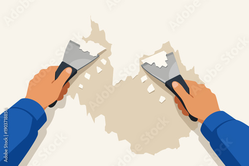 Hands scraping paint from a wall during renovation work with a putty knife