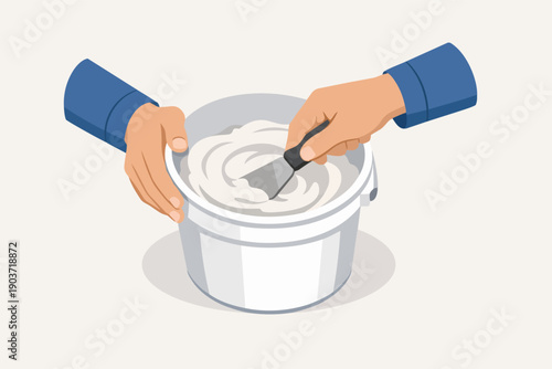 Hands holding a bucket accessing joint compound with a putty knife for wall repair