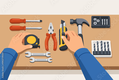 Hands organizing various repair tools on a workbench for diy and home renovation