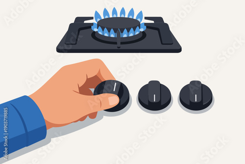 Hand adjusting gas stove knob, burner igniting blue flame in kitchen