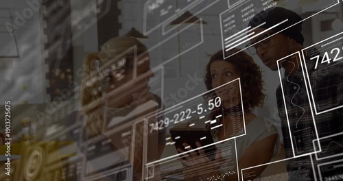 Collaborating coworkers viewing tablet in office, wearing blazer and beanie, with HUD overlays