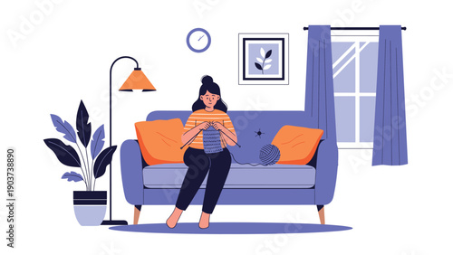 Young woman sits comfortably on a blue sofa in a cozy living room while knitting a blue scarf during a relaxing evening at home.