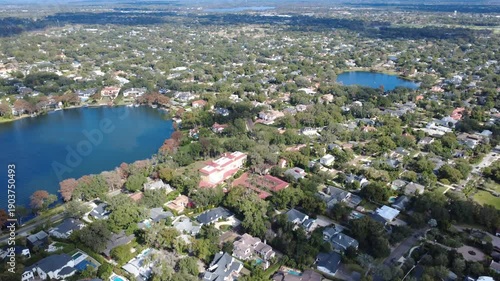 Aerial drone view of college campus and lakeside neighborhood surrounded by trees