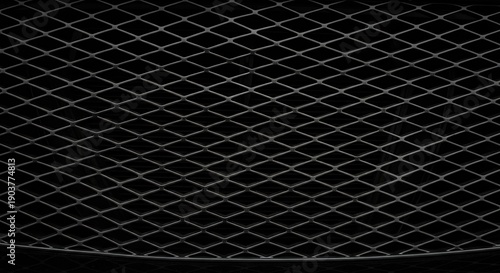 Closeup view of a black metal mesh with diamondshaped patterns and a dark background.