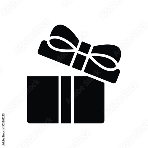 A closeup of a new pair of fashion leather shoes and a black gift box with a ribbon bow isolated on a white background for elegance and style
