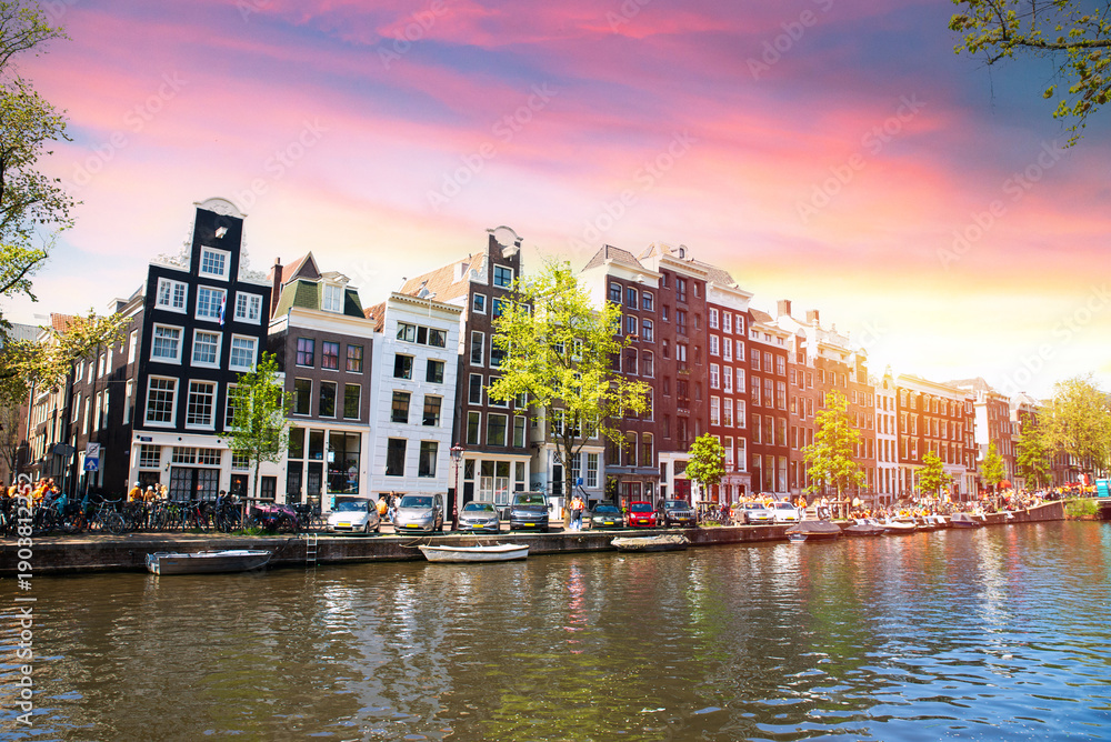 Obraz premium Facades of old historic Houses and trees over canal water, Amsterdam, Netherlands. High quality photo