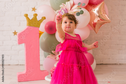 Baby girl  at first birthday with smash cake