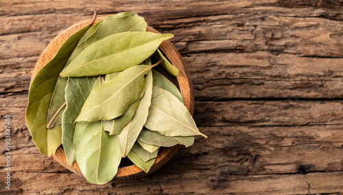 Tableau sur toile Bay leaves on a bowl against an wooden table background.
