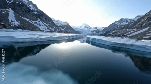 Wallpaper Mural A stunning expanse of a mountain, its rugged peaks and icy embrace mirrored in the still water of the glacial lake. FPV drone perspective landscape animation Torontodigital.ca
