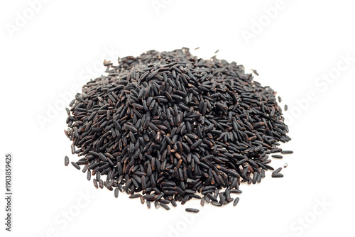 Obraz na plátně Black rice grains piled on a white background, showcasing their unique dark colo