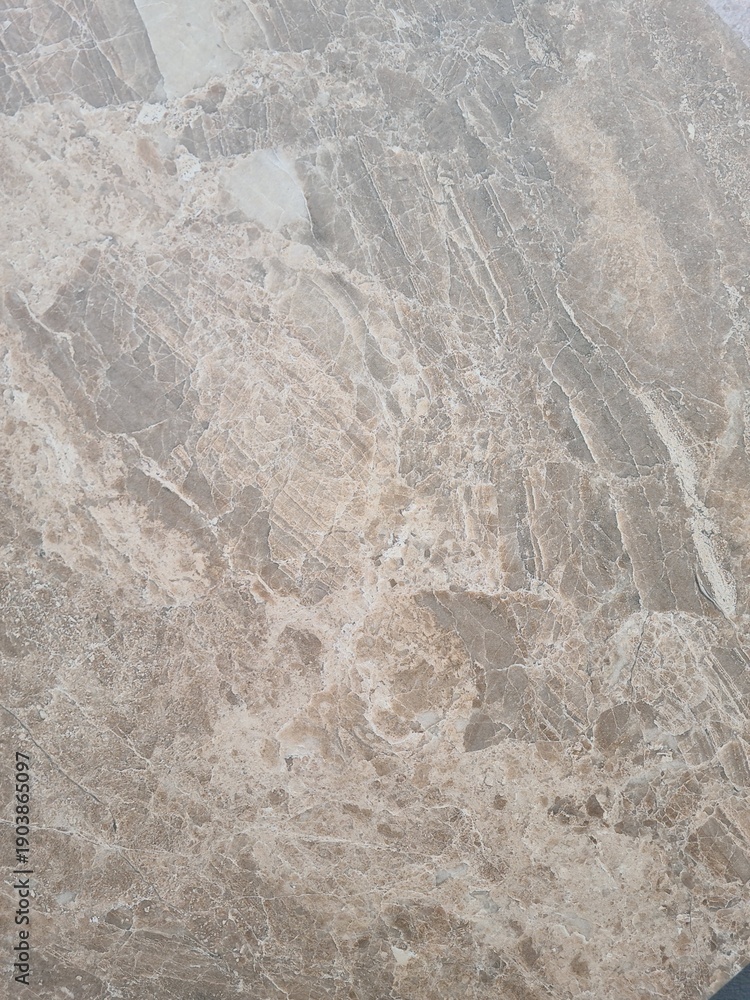 Obraz premium Close-up of a textured surface with a natural stone appearance. The surface features subtle patterns and variations in color, resembling marble or granite.