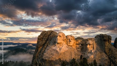 Mount Rushmore national memorial at sunrise with dramatic clouds and misty valley, iconic American landmark honoring United States presidents