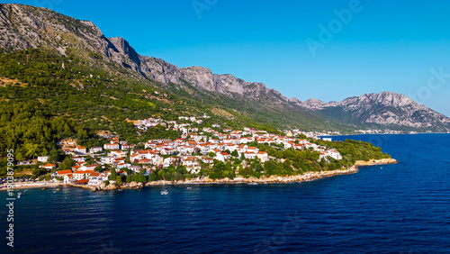 Aerial view of Croatian seaside town with red roofs and rocky coastline on Adriatic Sea