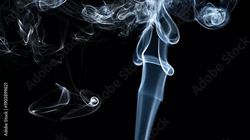 Wisps of white smoke curl upwards against a black background.