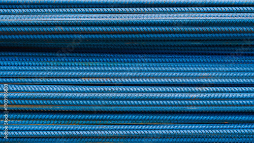 Blue steel rebar stacked in parallel rows for construction use